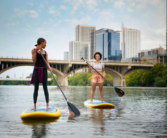 Travelers paddle boarding on Lady Bird Lake.